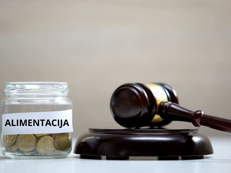 prikaz advokatske palice i teglice sa novcem na kojoj piše alimentacija